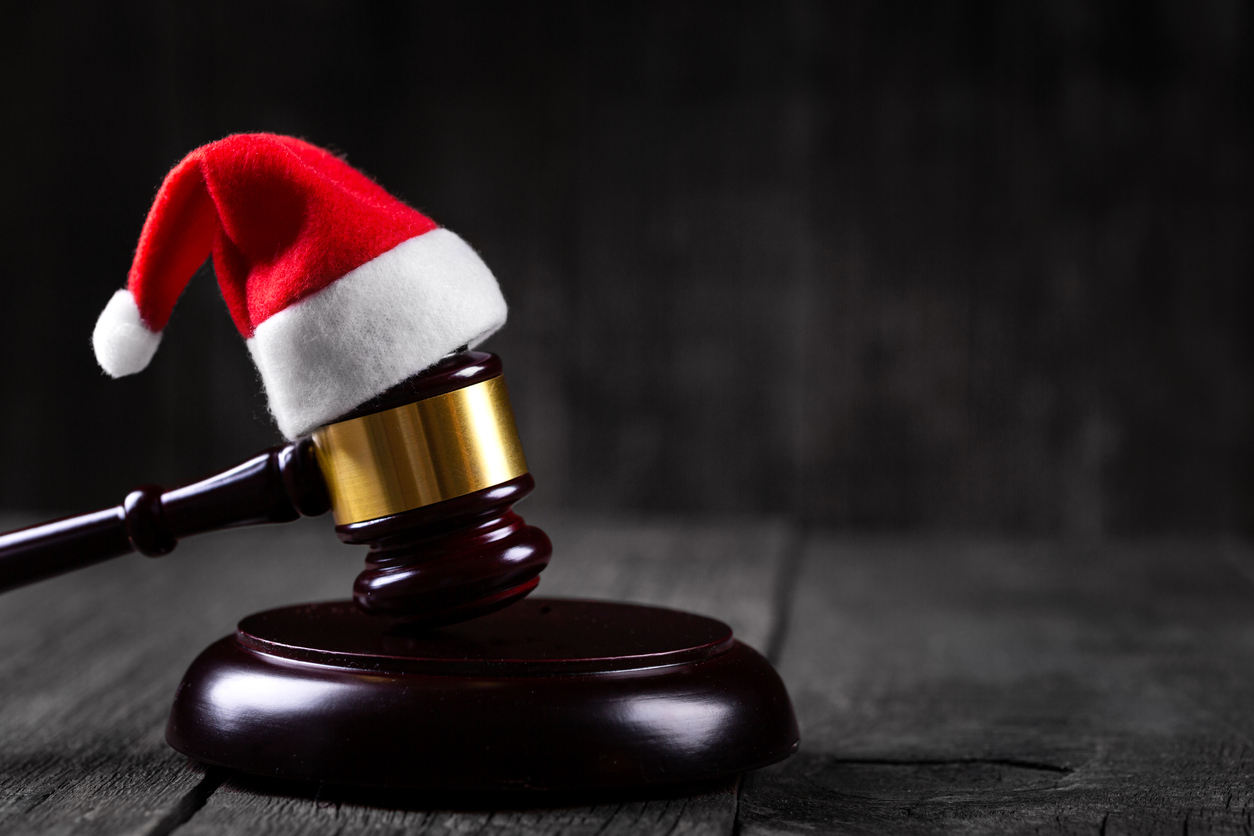 Santa Claus hat on Judge Gavel on wooden rustic background. Christmas and new year celebration. Winter holidays